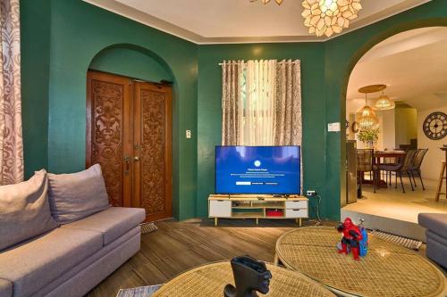 a living room with a couch and a flat screen tv at Dos Maya by Araw Residences in Nasugbu