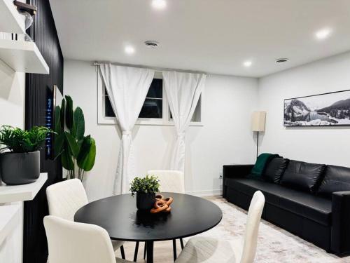 a living room with a table and a black couch at Luxury Stay Near Niagara Falls in Niagara Falls