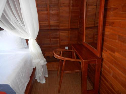 a bedroom with a bed and a desk with a chair at Grand Sinar Indah in Legian
