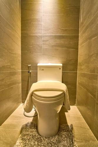 a bathroom with a toilet with a towel on it at Dos Maya by Araw Residences in Nasugbu