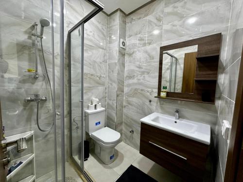 a bathroom with a shower and a toilet and a sink at APT Luxueux à 5 min de la Plage avec accès Piscine in Bouznika