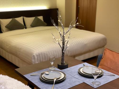 a table with plates and glasses and a bed at Hotel Global View Hakodate in Hakodate