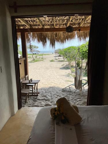 a teddy bear sitting on a bed in front of a beach at Casa Gitana in Chamuscadero