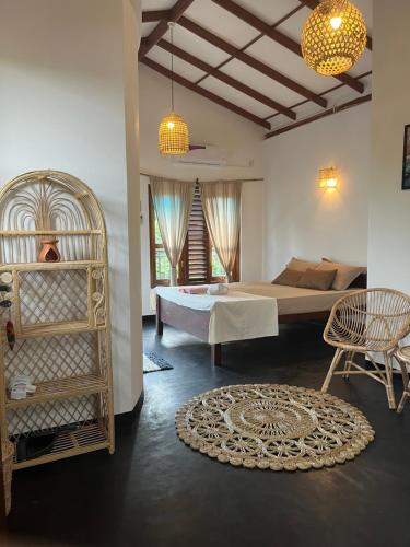 a bedroom with a bed and a table and chairs at Slow Life Boutique Hotel - Adults Only in Mirissa