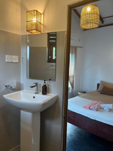a bathroom with a sink and a bed at Slow Life Boutique Hotel - Adults Only in Mirissa