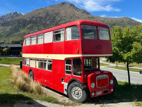 a red double decker bus parked on the side of a road at Decker Daze Queenstown in Queenstown