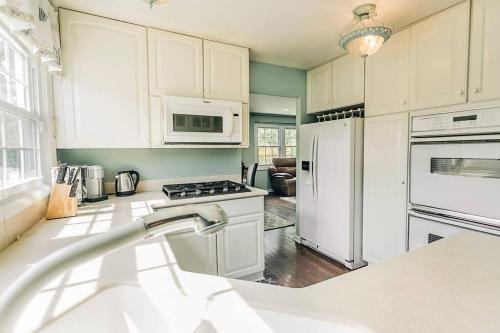 a kitchen with white cabinets and a white refrigerator at Cozy 4BR Home with 2by5 Baths in Schaumburg