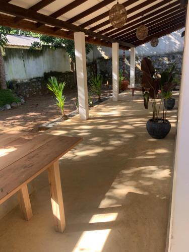 a wooden bench sitting under a covered patio at Pranaya Villa in Hiriketiya