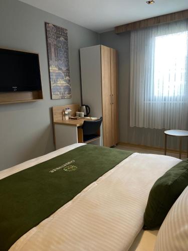a bedroom with a large bed with a flat screen tv at Gardenmode Airport Hotel in Taşoluk