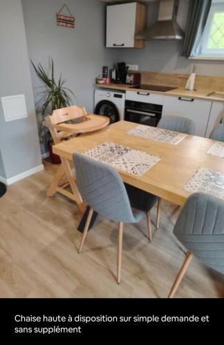 une cuisine avec une table et des chaises en bois dans l'établissement Gîte le petit wintz entre ville et vignes avec son parking et jardin privatif, à Wintzenheim