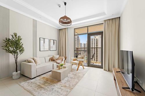 a living room with a couch and a tv at Silkhaus Vacation Homes Chic and Cozy 1 BR Nearby Reem Park in Abu Dhabi