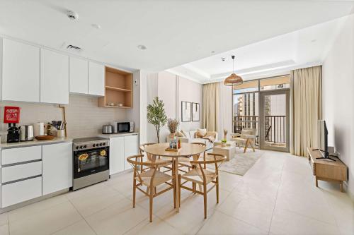 a kitchen and living room with a table and chairs at Silkhaus Vacation Homes Chic and Cozy 1 BR Nearby Reem Park in Abu Dhabi