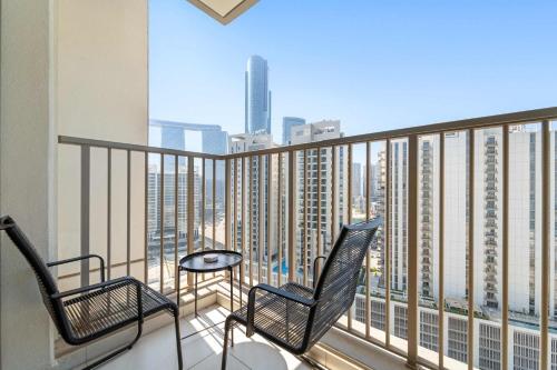 two chairs on a balcony with a view of a city at Silkhaus Vacation Homes Chic and Cozy 1 BR Nearby Reem Park in Abu Dhabi