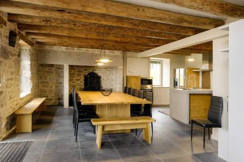 une grande cuisine avec une table et des chaises en bois dans l'établissement Maison chauvet 4 epis 10-12 pers aux monts-verts, à Le Bacon