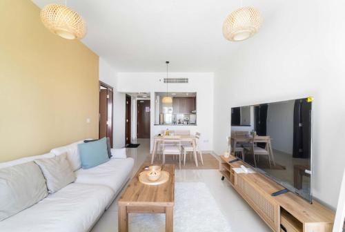 a living room with a white couch and a table at Silkhaus Vacation Homes Cozy 1BDR Near Reem Mall in Burooj Views in Abu Dhabi