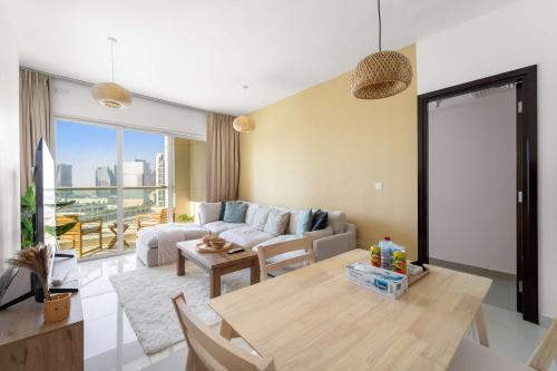 a living room with a couch and a table at Silkhaus Vacation Homes Cozy 1BDR Near Reem Mall in Burooj Views in Abu Dhabi