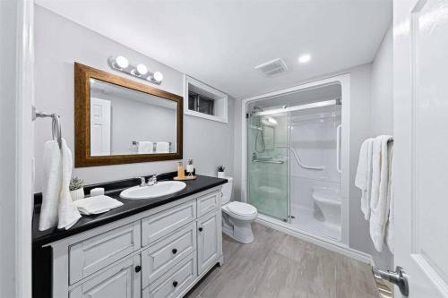 a white bathroom with a sink and a shower at Ultimate Lakeview Retreat - Hot Tub, Paddle & Play in Bancroft