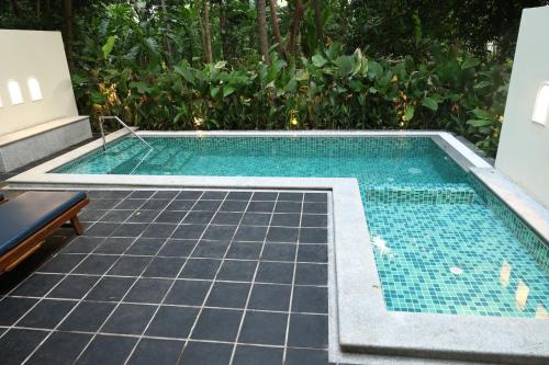 a swimming pool with a tiled floor at Mantra Koodam Kumbakonam - A CGH Earth Experience in Kumbakonam