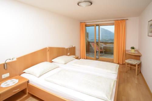 a bedroom with a large bed and a window at Kampflhof Apartments in Schenna