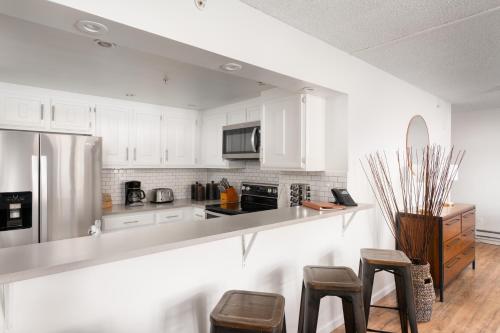 a kitchen with white cabinets and stainless steel appliances at Evergreen Lodge at Vail in Vail