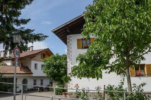 a white house with a tree in front of it at Kampflhof Apartments in Schenna