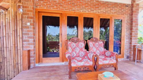 two chairs sitting on the porch of a house at Bunga Maliq Bungalow Lombok in Tetebatu