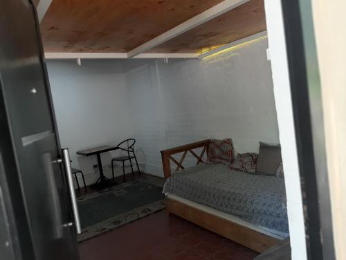 ein kleines Schlafzimmer mit einem Bett und einem Tisch in der Unterkunft Andino in La Cieneguita