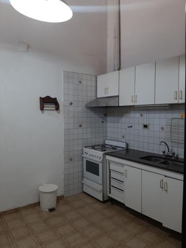 eine Küche mit weißen Schränken und einer Spüle und einem Herd in der Unterkunft Andino in La Cieneguita