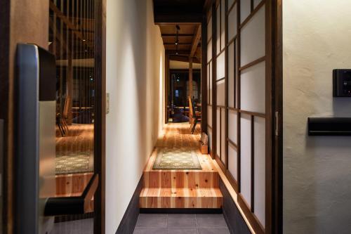 a hallway of a building with wooden floors and windows at 清水いにしえ庵 in Kyoto