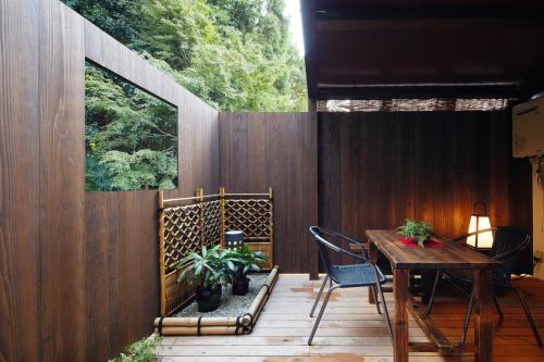 a patio with a wooden fence and a table and chairs at 清水いにしえ庵 in Kyoto