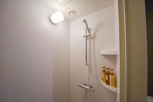 a bathroom with a shower and a toilet with a light at Setolive by 4S STAY in Takamatsu