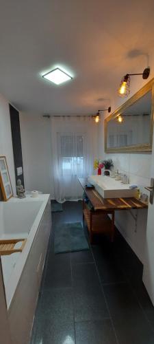 a bathroom with a large tub and a sink at Stilvoll & Wohlfühlfaktor! in Nohfelden