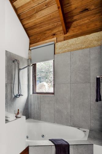 a bathroom with a bath tub and a window at Piermont Retreat in Swansea