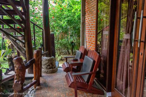 a porch with two chairs and a table at Green Travelodge Bukit Lawang in Bukit Lawang