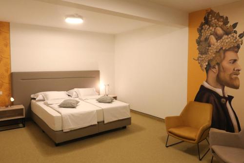 a bedroom with a bed and a painting of a man at VINOTEL BRZICA Aljmaš in Aljmaš