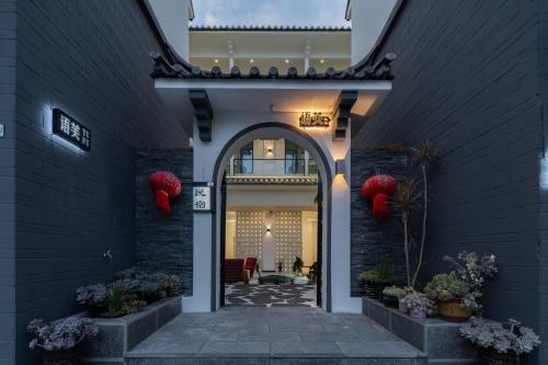 an entryway to a house with red lanterns at Dali Yufu B&B Hotel in Dali Shuanglang