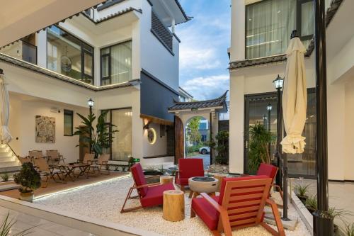 a house with a patio with chairs and a table at Dali Yufu B&B Hotel in Dali Shuanglang