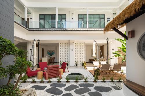 a house with a courtyard with red chairs at Dali Yufu B&B Hotel in Dali Shuanglang