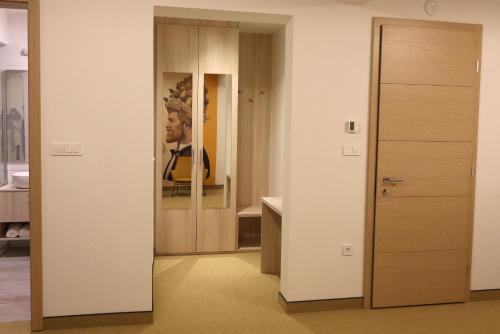 a door in a room with a painting of a man at VINOTEL BRZICA Aljmaš in Aljmaš