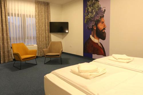 a room with a bed with a painting of a man at VINOTEL BRZICA Aljmaš in Aljmaš