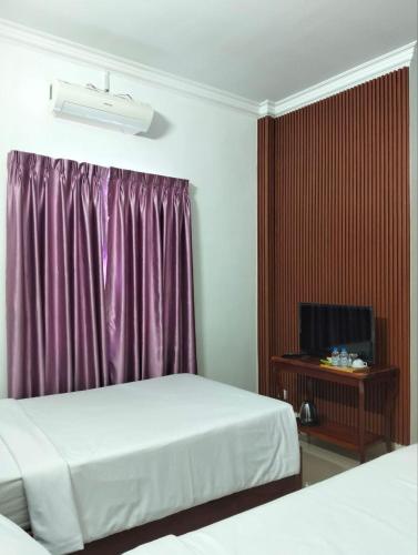 a hotel room with two beds and a tv at Angkor Sandra Villa in Siem Reap
