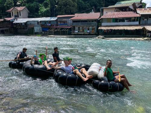 a group of people are riding on an raft in the water at Green Travelodge Bukit Lawang in Bukit Lawang
