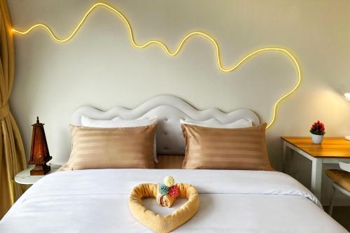 a bed with a teddy bear in a heart shaped towel at Scenic Condo 50 sqm Karon in Karon Beach
