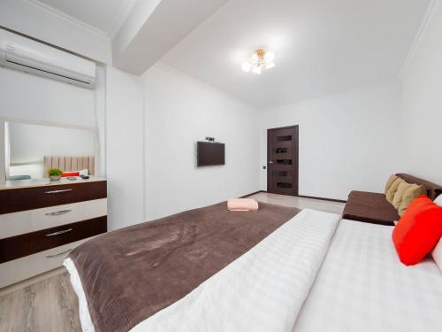 a bedroom with a large bed and a television at Appartments " Zhetysu-4" in Almaty