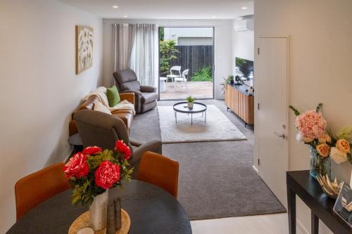 a living room with a table and chairs at Charming 3-Bedroom Escape Carpark in Christchurch