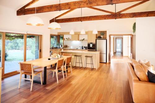 a kitchen and living room with a table and chairs at Yarradene Luxury Healesville Farmstay in Healesville