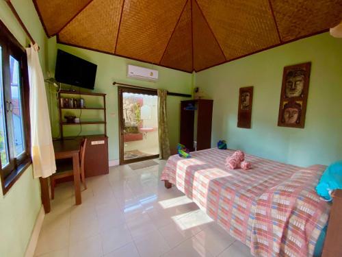 a bedroom with a bed with a pink stuffed animal on it at Shanti Lodge Phuket in Chalong 