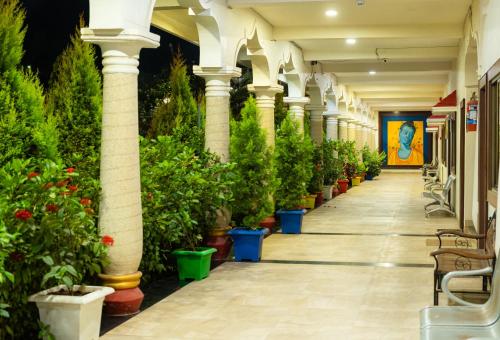 a corridor with potted plants in a building at Hotel Royal Palace in Sāgar
