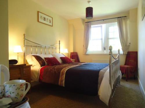 a bedroom with a large bed and a window at Tweed View B&B in Peebles
