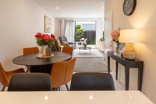 a living room with a table and chairs at Charming 3-Bedroom Escape Carpark in Christchurch